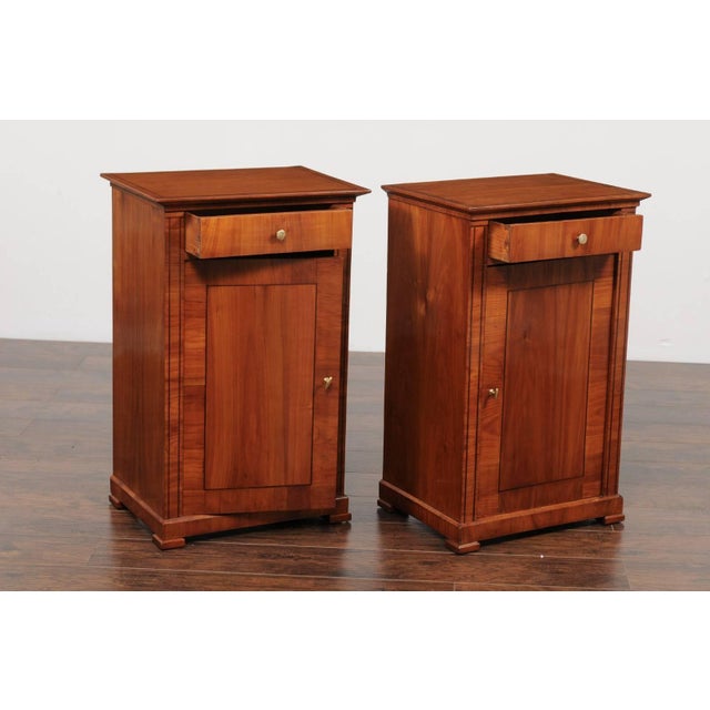 A pair of Austrian Biedermeier style walnut veneered cabinets with banded inlay from the second half of the 19th century....