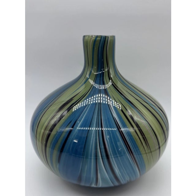 Striking and vibrant, this vintage Murano-style hand blown art glass vase features a beautiful swirl pattern in rich blue,...