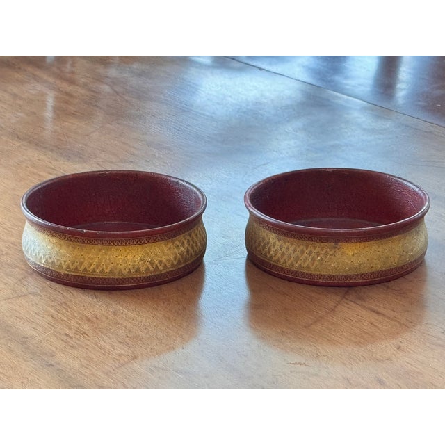 A matched pair of 19th century red wine coasters with a deep red interior and gilt-decorated exterior band. Circular form...