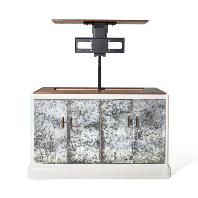 Custom designed antiqued mirror front cabinet featuring a hidden, mechanized TV lift. The piece from S.R. Gambrel...