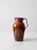 This hand-crafted studio pottery pitcher, dated 1983 and signed by the artist, features a warm brown and rose glaze with...