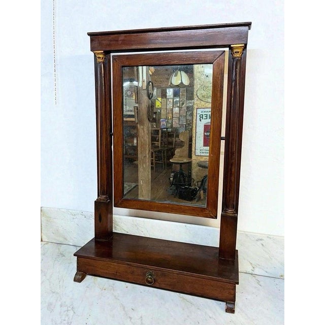 An elegant 19th century mahogany psyche or dressing mirror, designed in the Empire style and enriched with decorative gilt...
