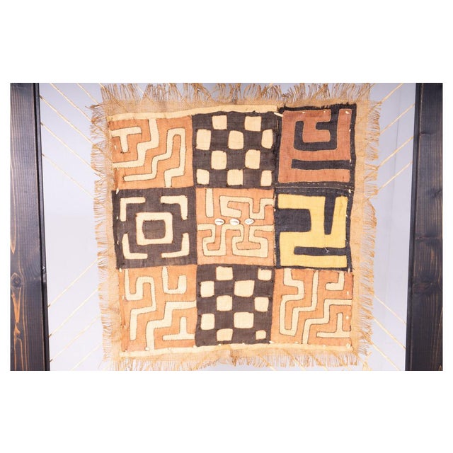 This captivating ethnic artwork features a fabric with warm tones and geometric patterns inspired by African tribal art....