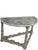 A refined pair of highly decorative demi-lune wall consoles finished in a soft gray-white painted surface. Each console...