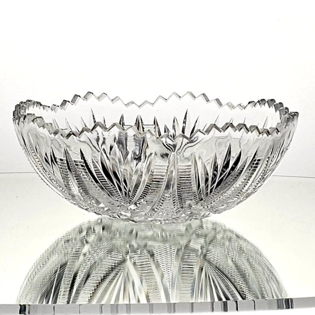 This American Brilliant Period cut glass bowl features a striking hobstar and saw tooth design, boasting an impressive...