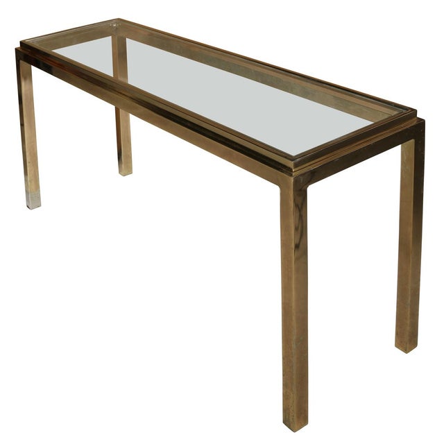 A Mastercraft style, vintage console table crafted in polished brass with a glass top in a clean architectural form. The...