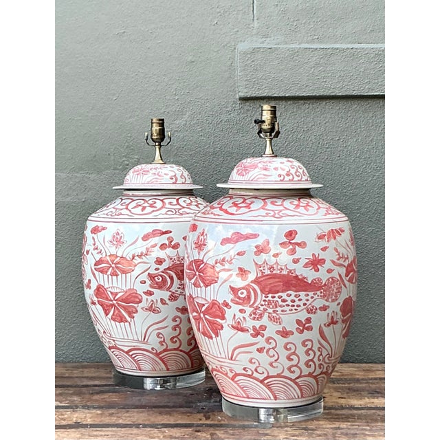 Make a splash in your interior with this grand pair of vintage porcelain ginger jar lamps. Executed in a classic iron red...