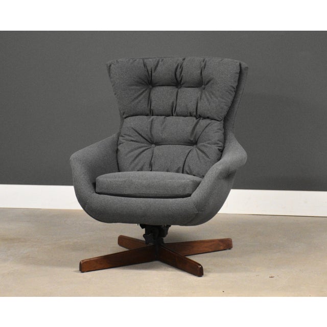 A mid century modern newly reupholstered grey lounge chair with a swivel walnut base made by Selig . Seat height 18”...