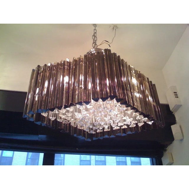A Murano glass chandelier in a diamond shape composed of clear and smoked crystals on a chrome frame.
