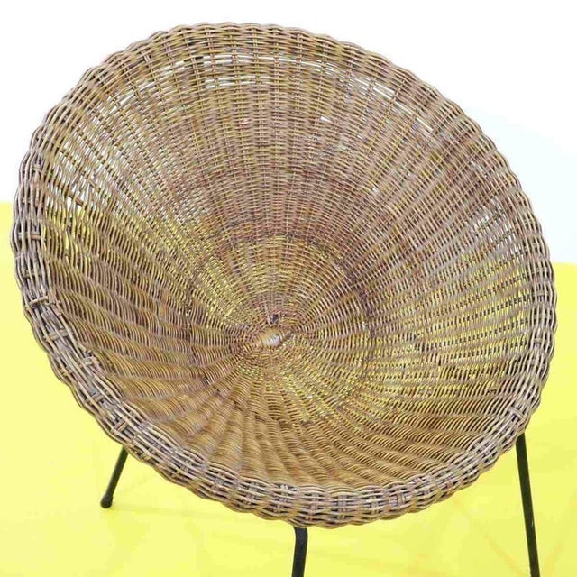 Comfortable wicker and metal armchair with a rounded structure.