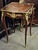 Elegant French-style side table featuring a sophisticated glass top that beautifully showcases the decorative artwork...