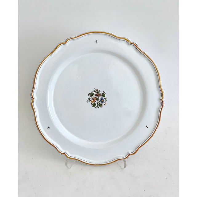 French Faience scalloped platter or charger from Moustiers-Sainte-Marie hand-painted and signed by the artist. There are...