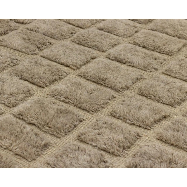 Exquisite hand-knotted wool rug in Misty Taupe, showcasing an eye-catching pattern of checks, effortlessly complements...