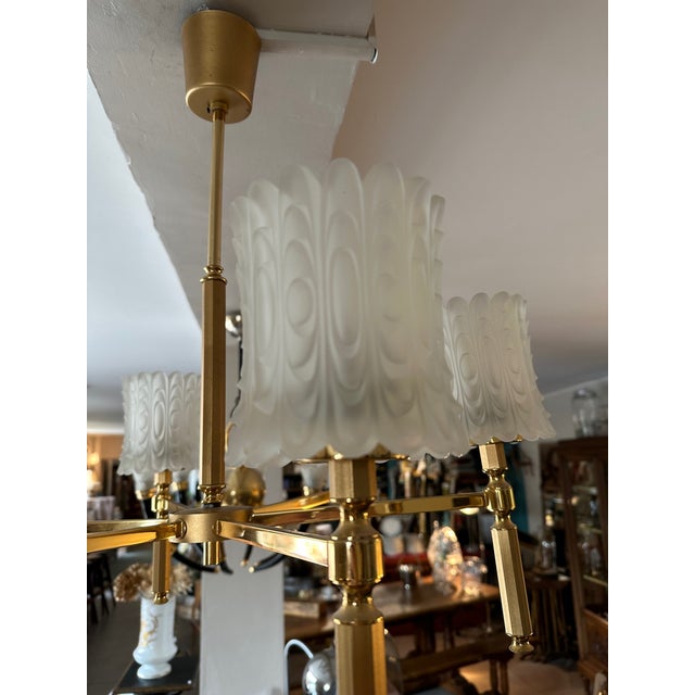 Very beautiful chandelier of the 70s in brass and six lampshades in carved and opaque glass. Very good state. Very elegant...