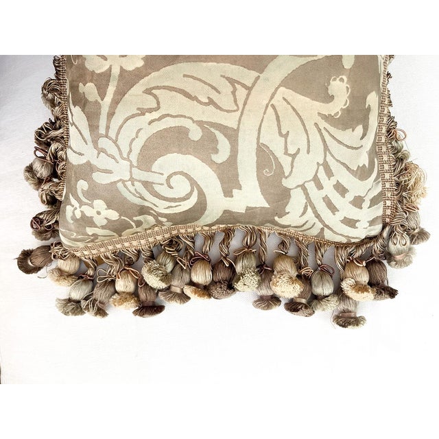 This pillow is made of vintage Fortuny fabric. It is lined with fringe and tassels.