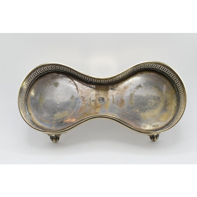 This is a silver plated stand. It can hold two wine bottles. It is from the early 20th century. It is not marked.