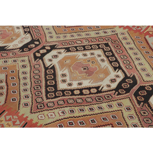 Hand woven in Turkey originating between 1950-1960, this vintage mid-century wool kilim hails from the city of Malatya,...