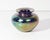 A 1973 art glass vase from Glass Eye Studio. This vase features a low, rounded shape with an iridescent feather pulled...