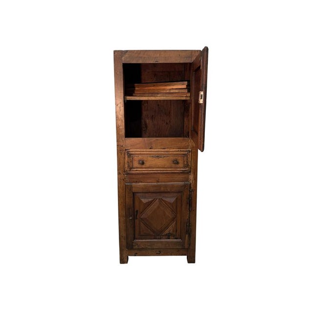 An elegant 19th-century tall sideboard crafted from fine walnut, this tall cabinet features a sleek, imposing silhouette....