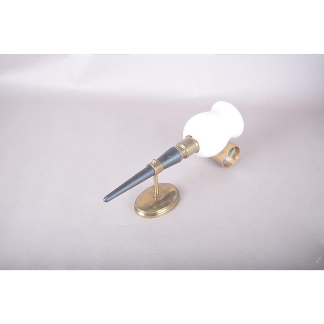 Single horn-form wall lamp with a tapering black lacquered body, brass bands and a brass swivel mount. The cloud-shaped...