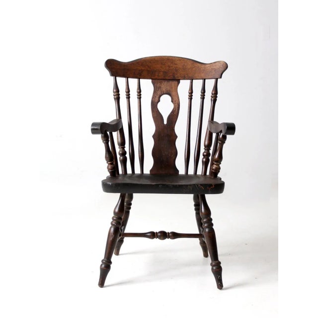 This is a mid 20th century Nichols & Stone arm chair. The Windsor style chair features a cut out center splat with spindle...