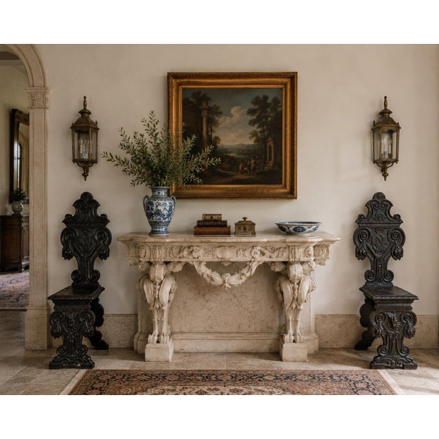 A striking pair of antique Italian Renaissance Revival hall chairs crafted from richly toned walnut and adorned with...