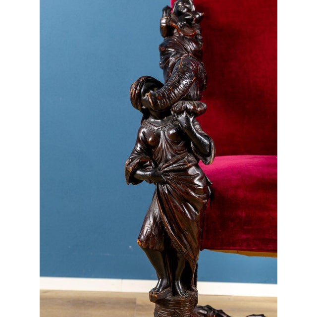 Magnificent armchair in finely carved wood, decorated with extraordinary sculptural motifs depicting musical Moors that...