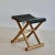 A pair of small folding stools, light wood base, stretched black leatherette seat. France 80s