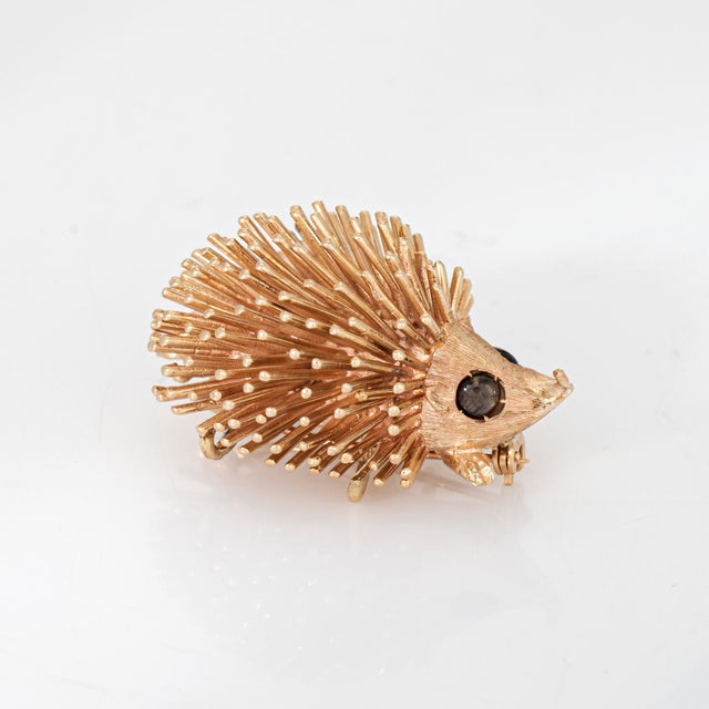 Finely detailed vintage Hedgehog pendant/brooch crafted in 14k yellow gold (circa 1970s). Two cabochon cut black star...
