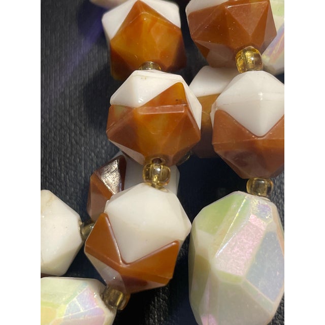 This mid-century West German costume necklace features molded plastic/lucite beads engineered with a two-piece...