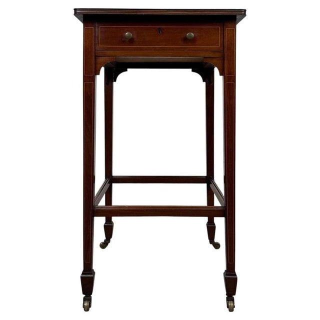 A refined 19th-century English side table, finely crafted from mahogany and distinguished by delicate satinwood stringing,...