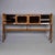 A sculptural bar cabinet in beech, finished in two tones — a deeper stain on the dramatically splayed A-frame legs and...