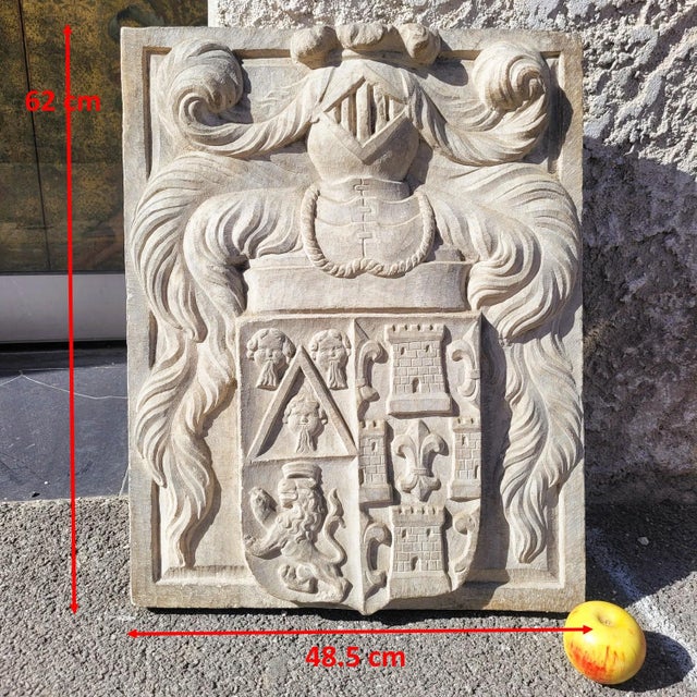 Large, finely sculpted marble coat of arms surmounted by a knight's helmet and surrounded by richly decorated mantling...
