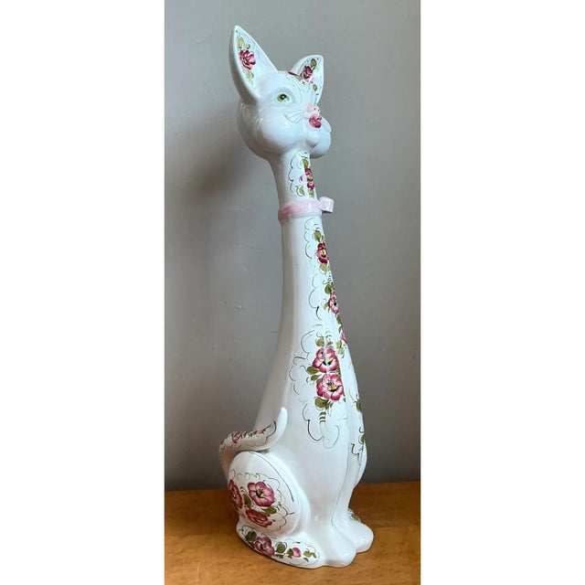 This whimsical figurine reimagines the classic cat form through an intentionally exaggerated, elongated silhouette, its...