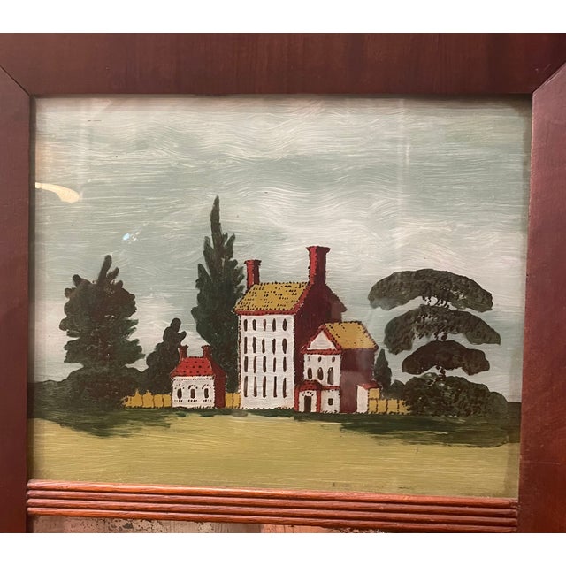 A late 19th, early 20th century Federal style mahogany mirror with a charming reverse painting on glass of a country house...