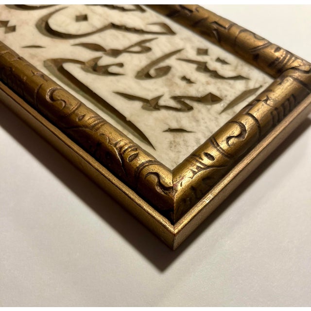Presenting a stunning piece of Arabic calligraphy art, delicately carved on a polished marble slab. This elegant artwork...