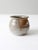 This vintage studio pottery vase is handmade and features a rich, earthy glaze with warm browns, soft grays, and creamy...