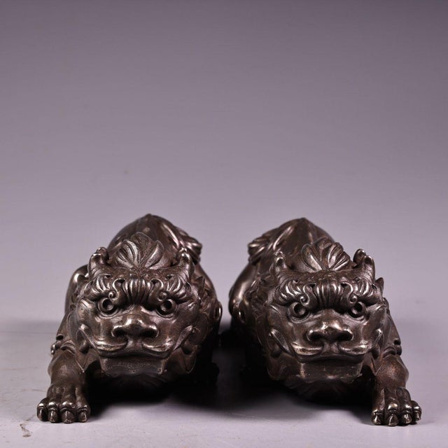 This is a matching pair of silver-plated guardian lion (Pixiu) figurines, featuring detailed high-relief (repoussé) and...