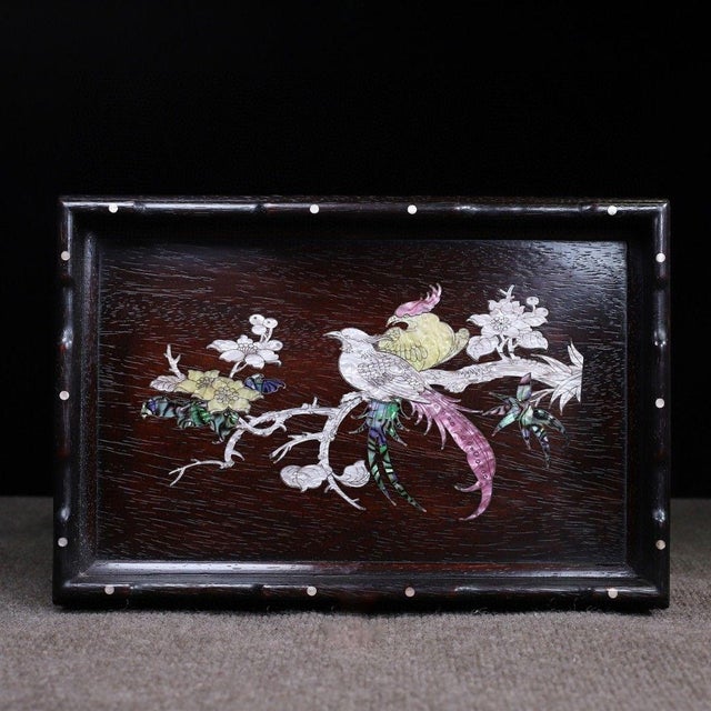 This is a beautifully crafted rectangular wooden tray featuring intricate mother-of-pearl (nacre) inlay work. Crafted from...