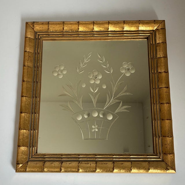 Charming vintage decorative mirror featuring a frosted etched floral basket motif surrounded by a warm gilt frame with...
