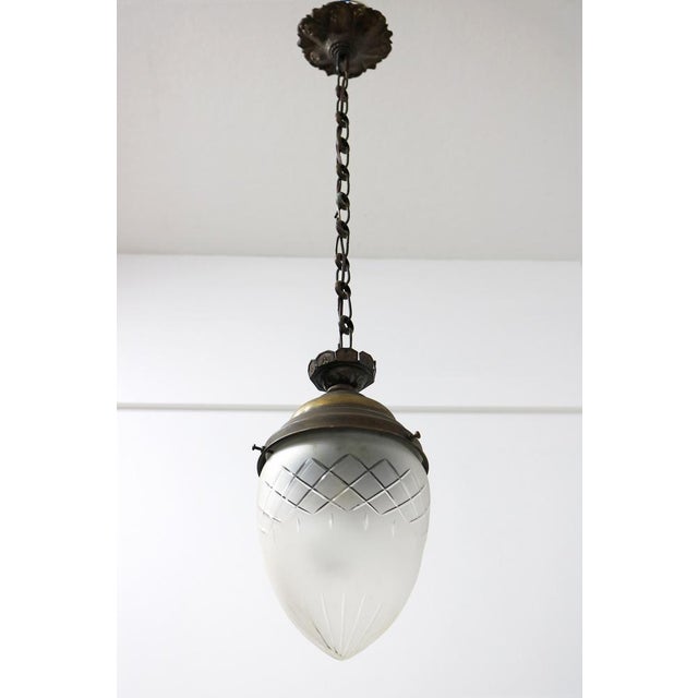 A charming antique French pendant light featuring an elegant teardrop silhouette, ideal for adding timeless character to a...