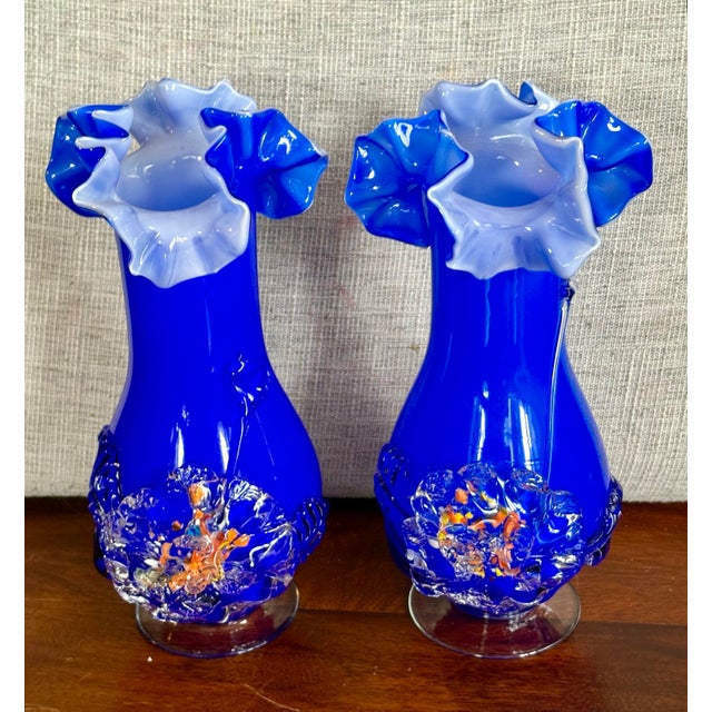 A striking pair of vintage Murano-style art glass vases, rendered in a deep blue with fine thread detailing and orange...