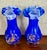 A striking pair of vintage Murano-style art glass vases, rendered in a deep blue with fine thread detailing and orange...