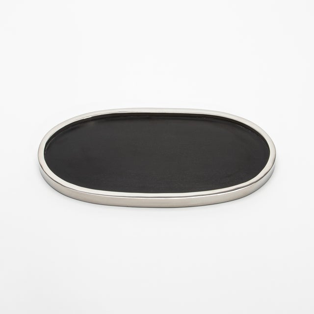 The Kifu Paris Oval Tray in black oak with polished stainless steel is a striking fusion of natural warmth and modern...