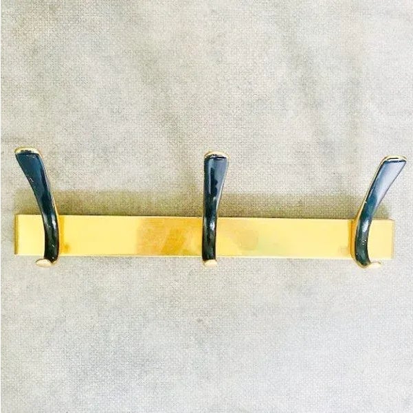 Vintage Gold Metal Hollywood Regency Wall coat rack, from Germany made in the 60s. This coat rack has black enamelled...
