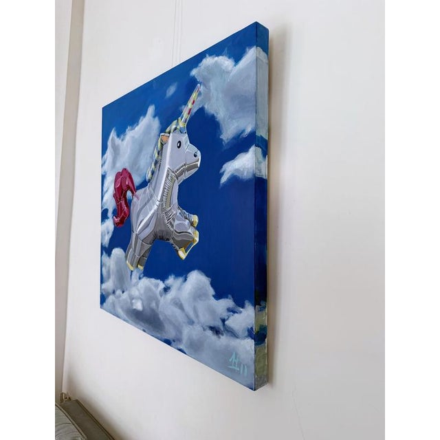 Acrylic painting depicting a silver inflatable unicorn suspended within a deep blue sky populated by layered cloud...