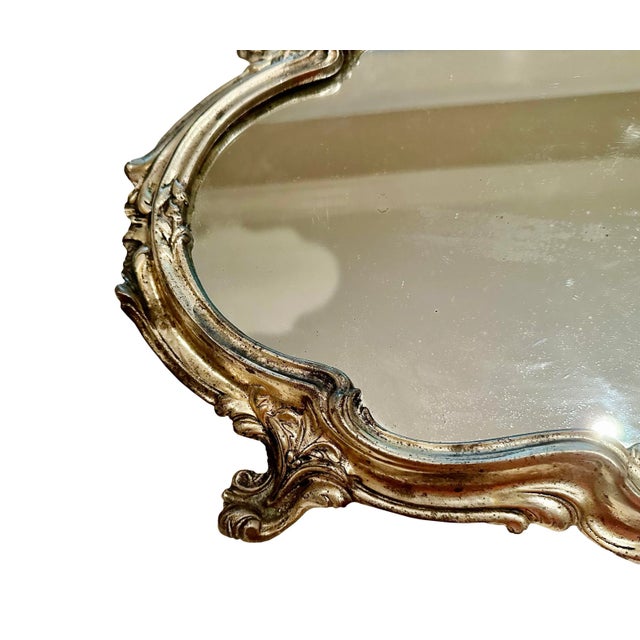 A beautiful French rococo style silver plate plateau. Footed with a mirrored top. Circa 1920s, France.