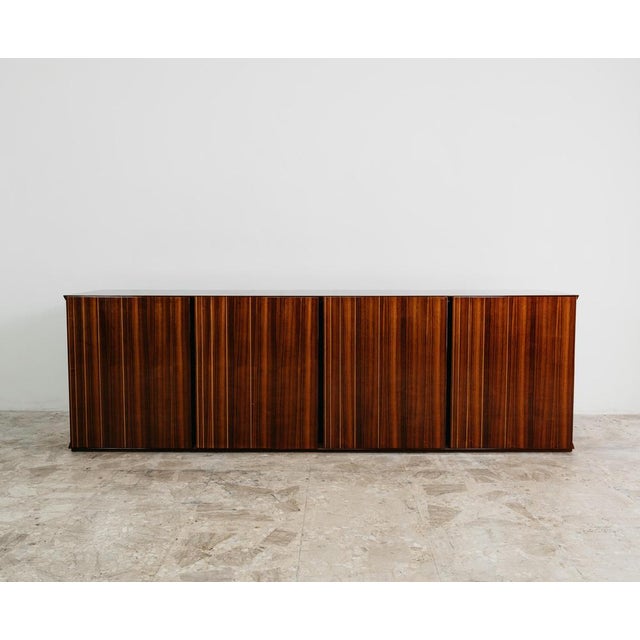 Monumental rosewood sideboard, made in Italy in the 1970s, a fine example of the craftsmanship and elegant design typical...