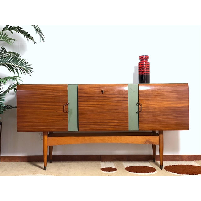 Sideboard cabinet from the 1960s of Italian manufacture, solid beech wood structure, sage green satin glass shelf, brass...