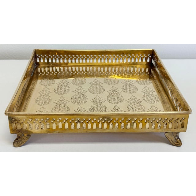 Beautiful vintage Hollywood Regency style square brass tray with perforated framed rail. Footed with etched pineapples to...